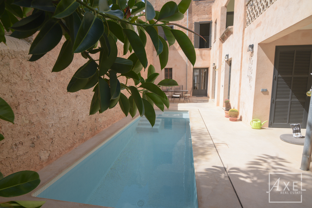 Elegante casa adosada en Campos, recién reformada, con patio, piscina y encanto histórico.